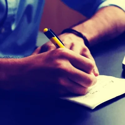A hand writing in a notebook