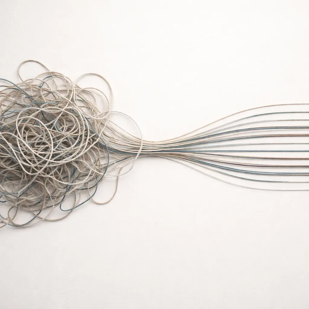 A tangle of threads resolving into straight, parallel lines